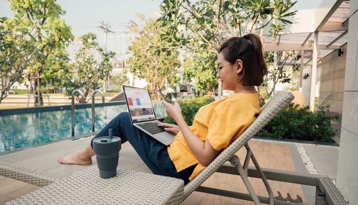 Woman with laptop at pool