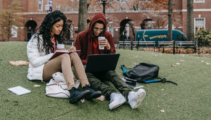 Students sitting in the park and studying